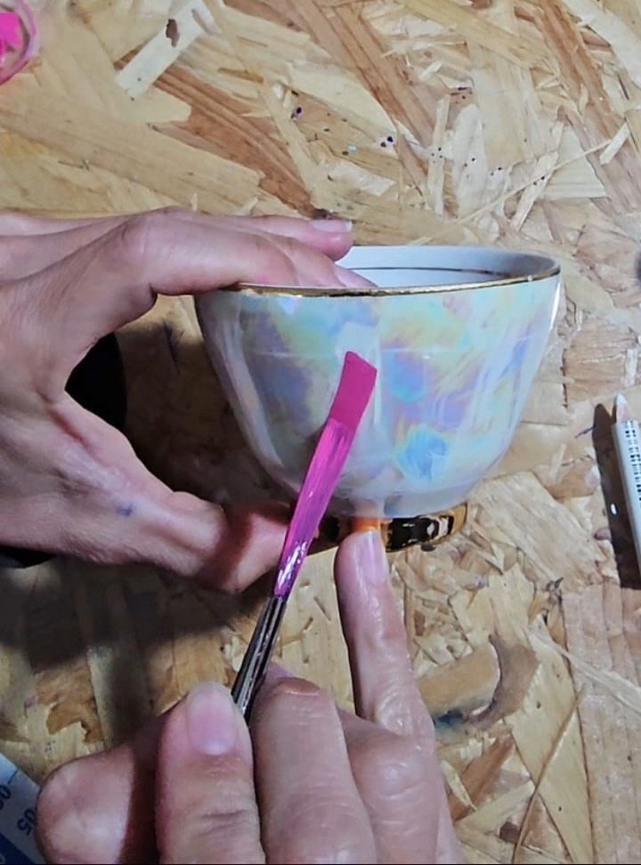 Hand holding signpainting brush at 45 degree angle for smooth, controlled strokes