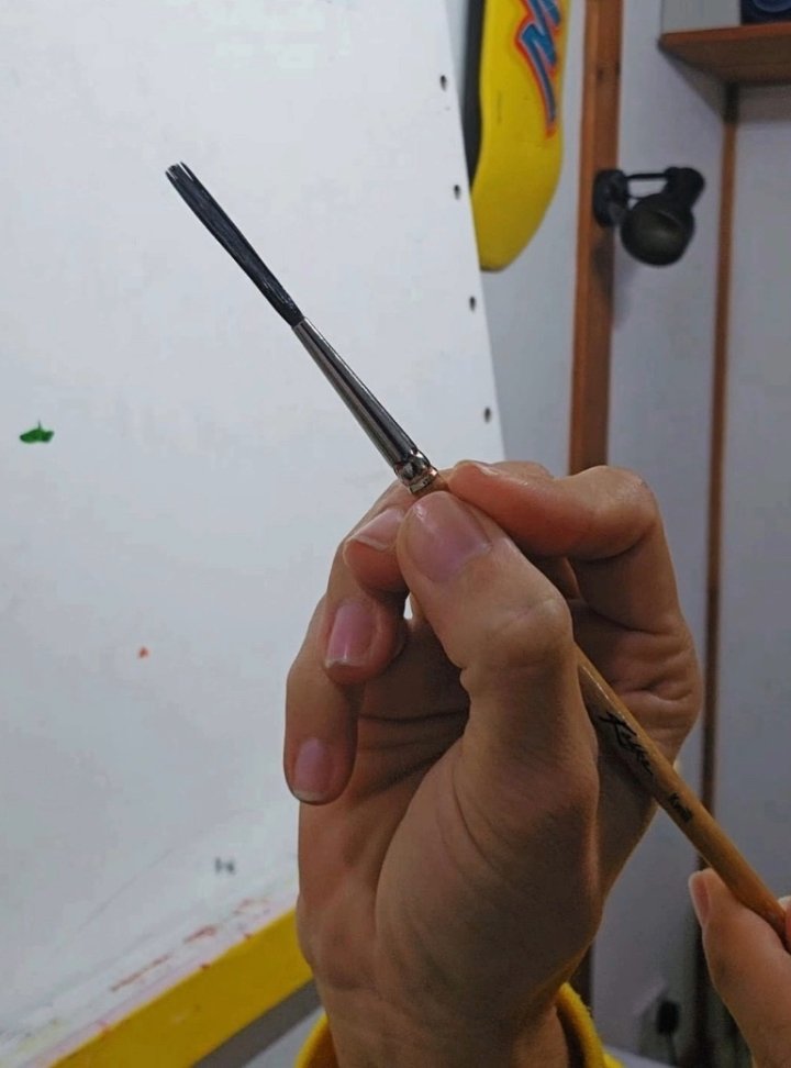 Demonstration of proper grip 1 cm from ferrule to improve brush control in signwriting
