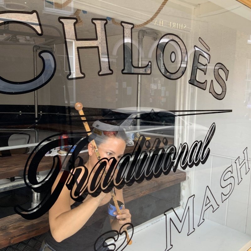 Front shop window painted by hand using traditional signwriting methods done in England by signwriter Joha Mune